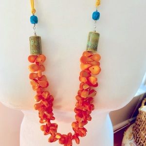 Orange coral briolette necklace with glass and a turquoise stone accent.